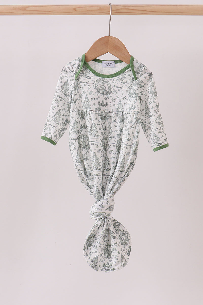 Green and white patterned baby outfit on a hanger against a light background